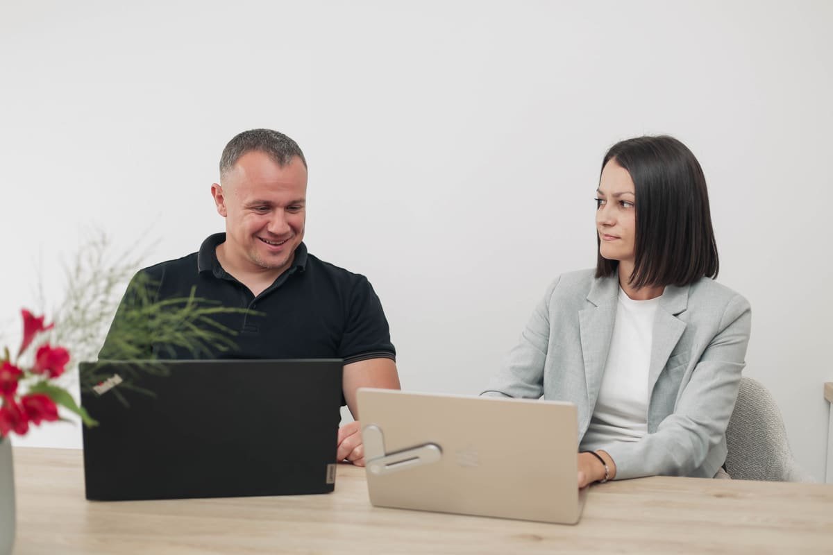 Zwei TekPiq-Kollegen beim Pair-Programming mit Laptops am Besprechungstisch