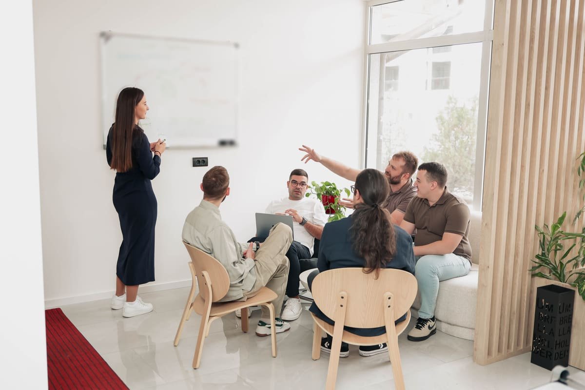 Ein TekPiq-Teammitglied leitet am Whiteboard ein Design-Review, während die Entwickler diskutieren