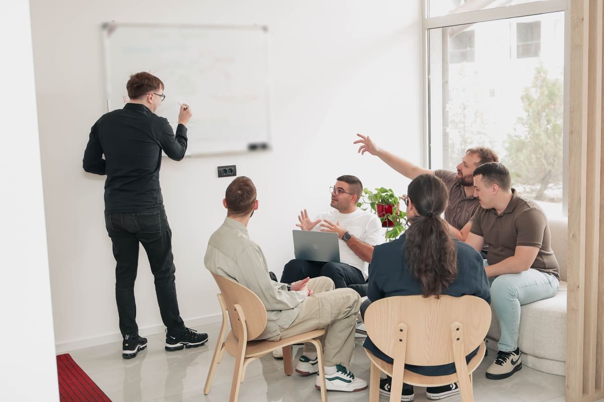 TekPiq-Entwickler in einer Architektur-Session am Whiteboard; einer von ihnen skizziert das Datenmodell